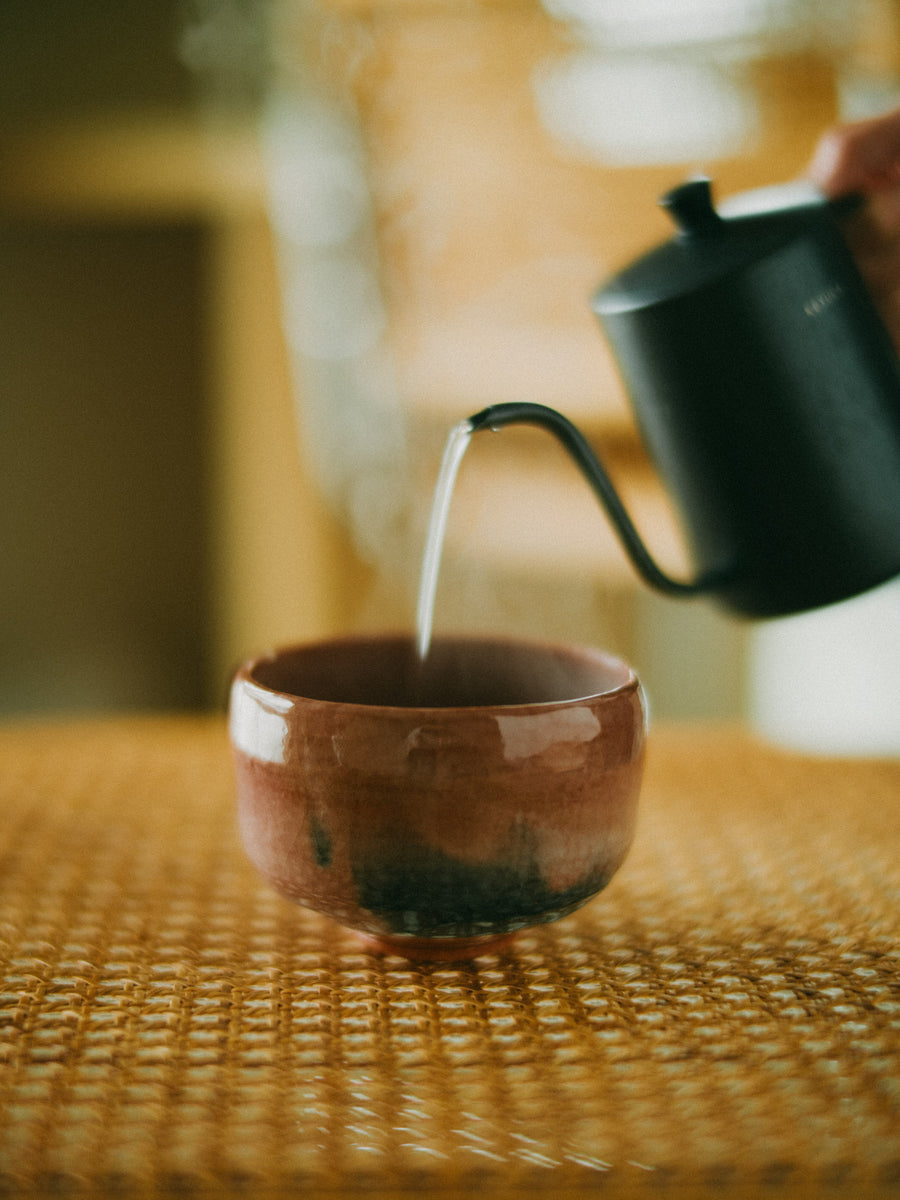 Pouring hot water into a matcha bowl