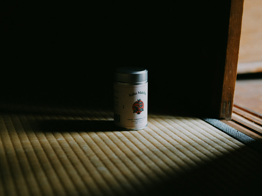 A sealed tin of matcha in a shaft of light in a dark room