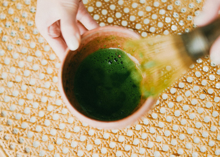 Whisking matcha before pouring it over ice